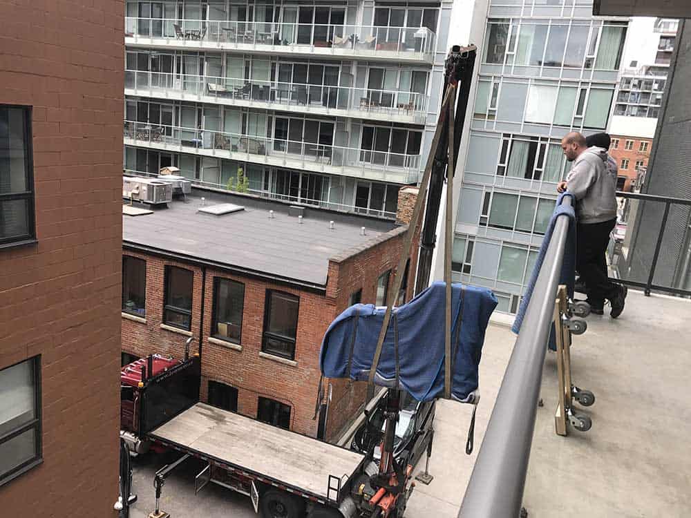 Piano being craned up to a Toronto balcony.