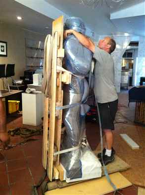 Preparing a marble statue which has to go down a flight of stairs outside.