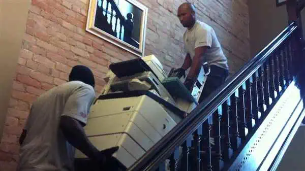 Moving a photocopier down a flight of stairs.