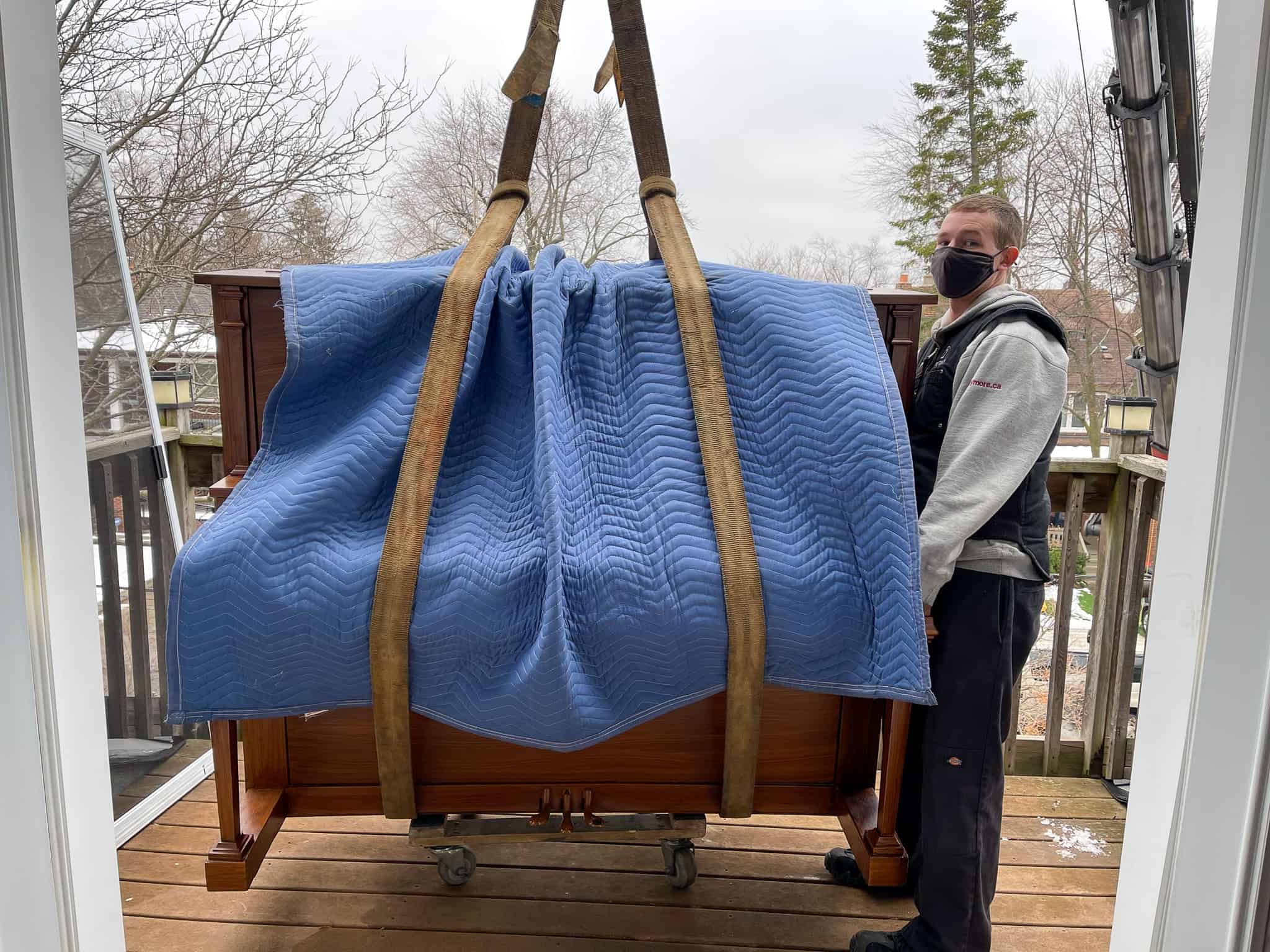 Crane upright piano off of balcony.