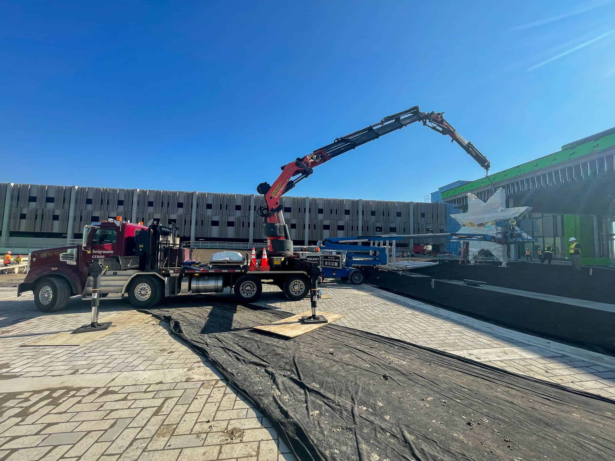 PK92002 Crane placing an outdoor sculpture in front of a commercial building.
