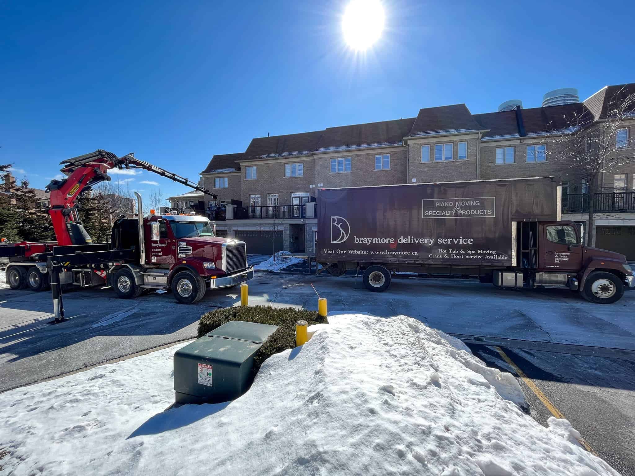 Using a crane to lift an upright piano onto a garage balcony that would not fit up the stairs