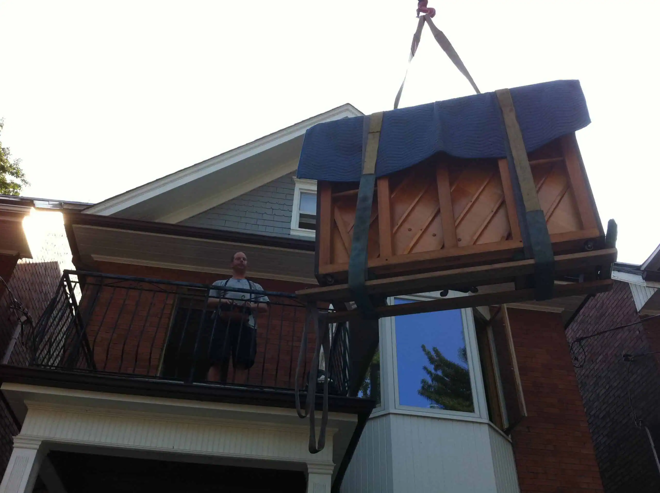 craning an upright piano to a second floor balcony that would not fit upstairs