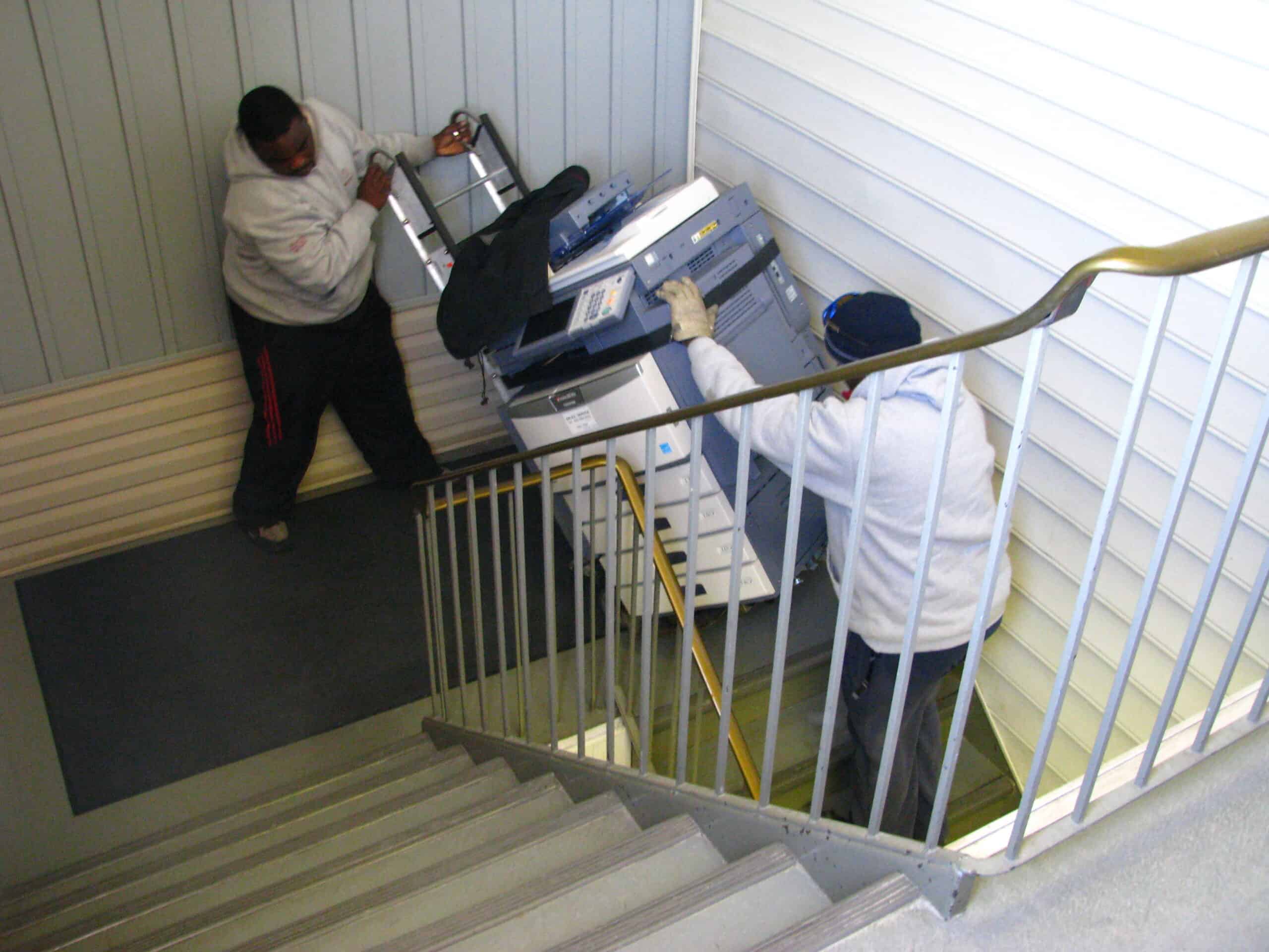 Carrying a photocopier up a switch back staircase.