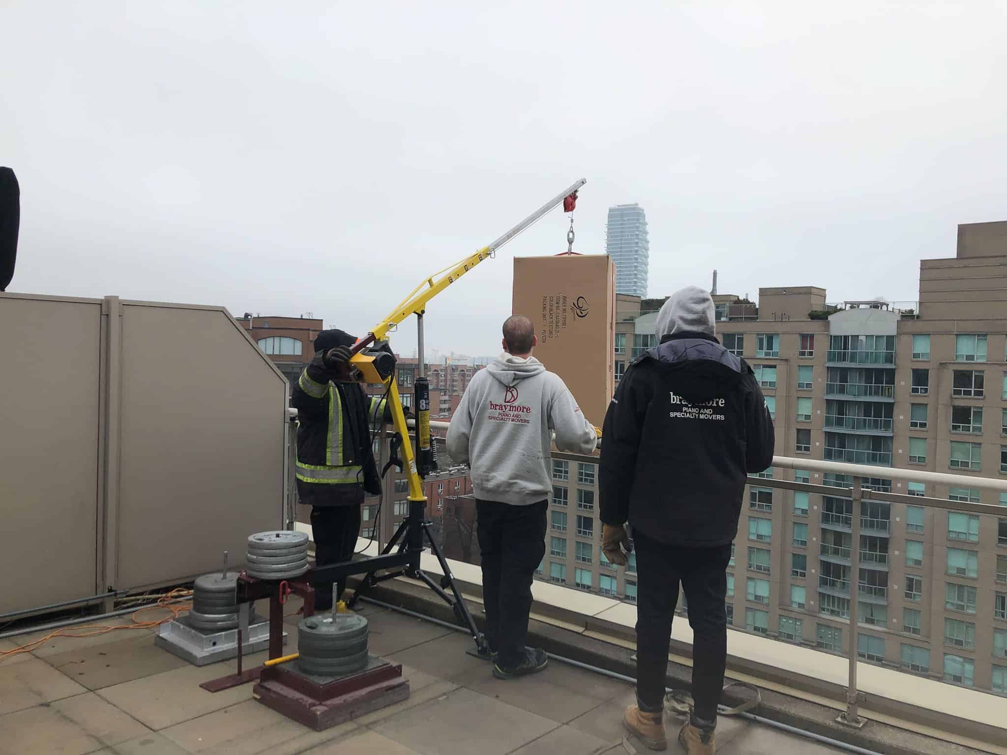 Balcony crane lifting patio furniture up onto condo balcony