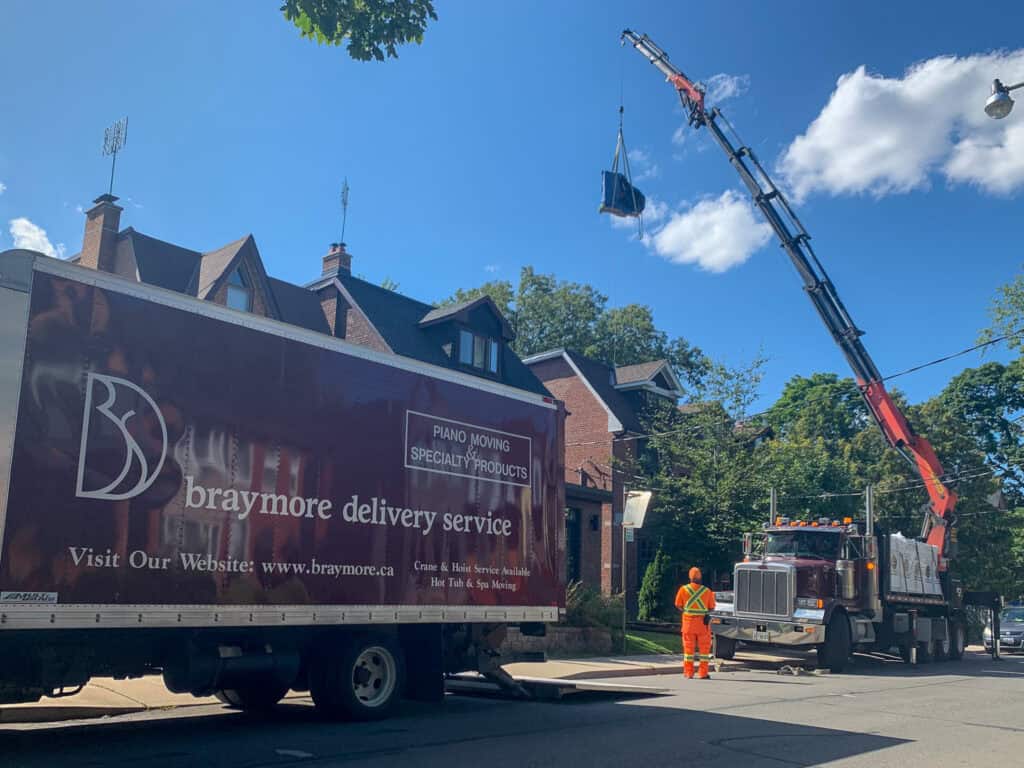 Lifting a grand piano over a house and onto a backyard second floor balcony.