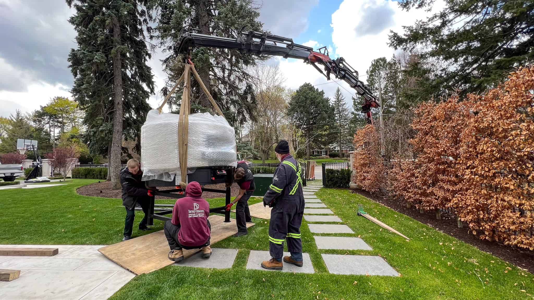 Crane placing a 3600 pound pizza oven on its stand.
