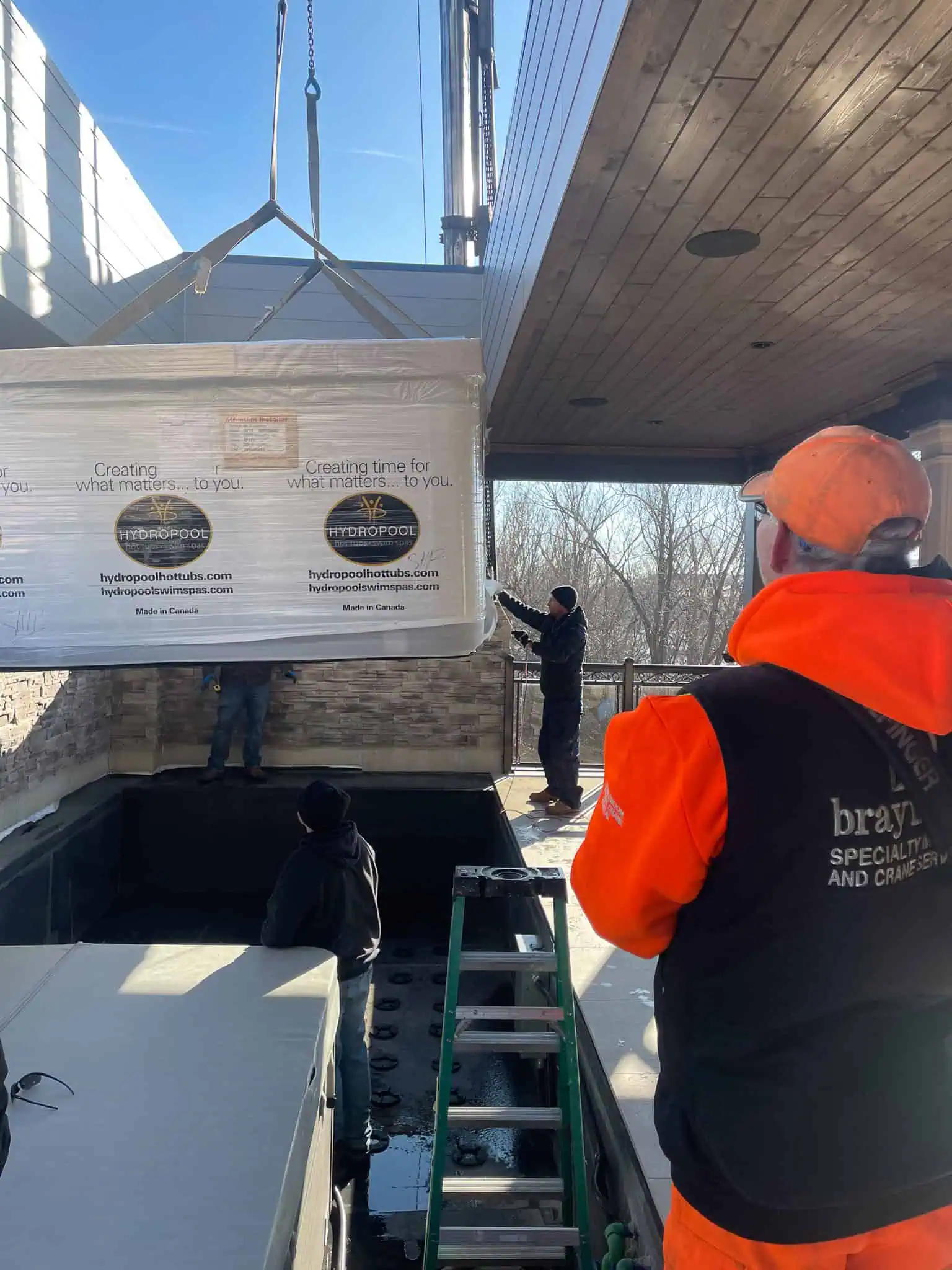 PK92002 Knuckle crane lowering a swim spa into a balcony.