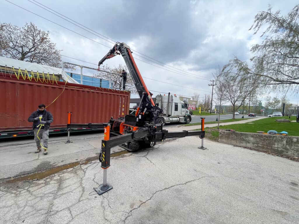 Spider crane offloading an open top container.