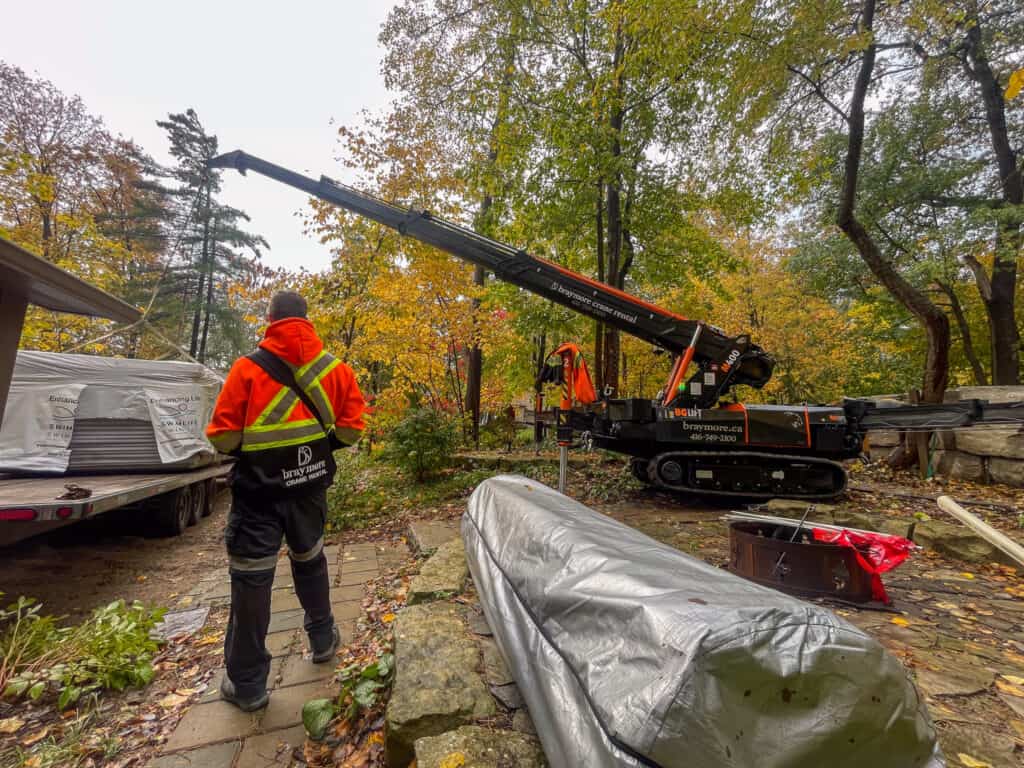 Mini Crane lifting a swim spa off a flatbed trailer.