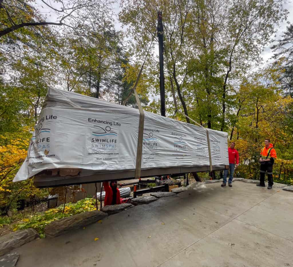 Craning a 2200 pound swim spa up onto a raised concrete patio.