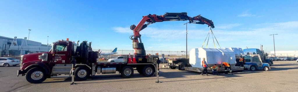 Crane cargo onto tractor trailer at the airport.