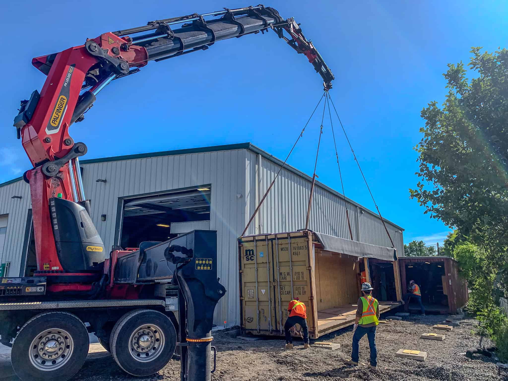 Palfinger PK135002 placing a series of containers together to create a storage building.