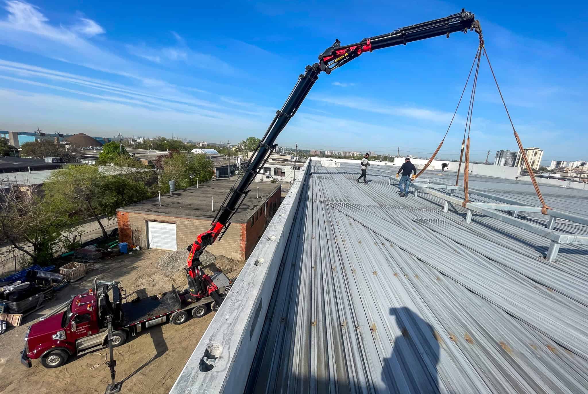 Palfinger 135002 craning steel frames onto roof of commercial buildings.