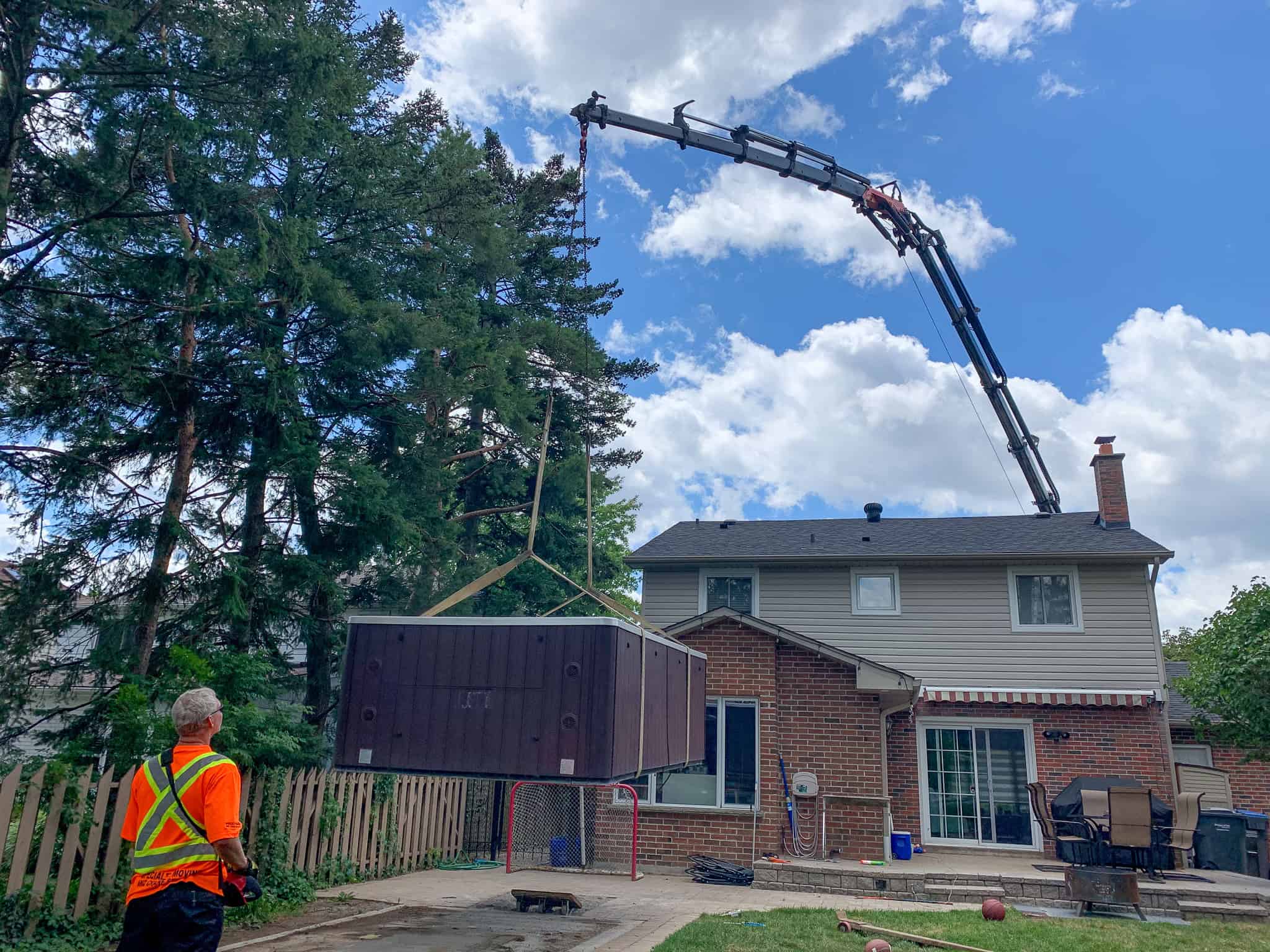 Crane a swim spa into a backyard in Mississauga, Ontario.