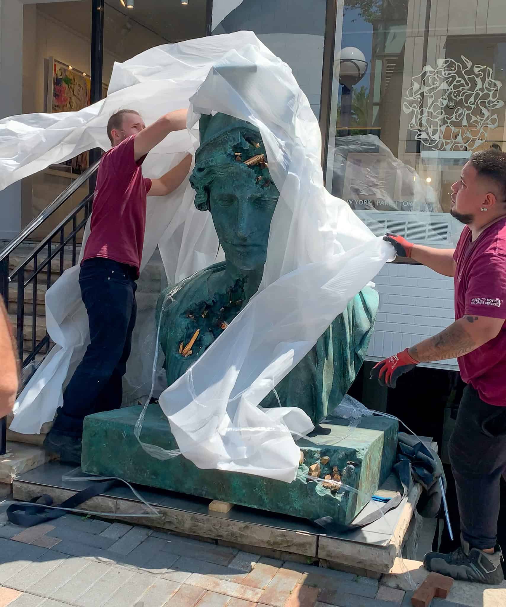 Unwrapping a statue in Toronto.