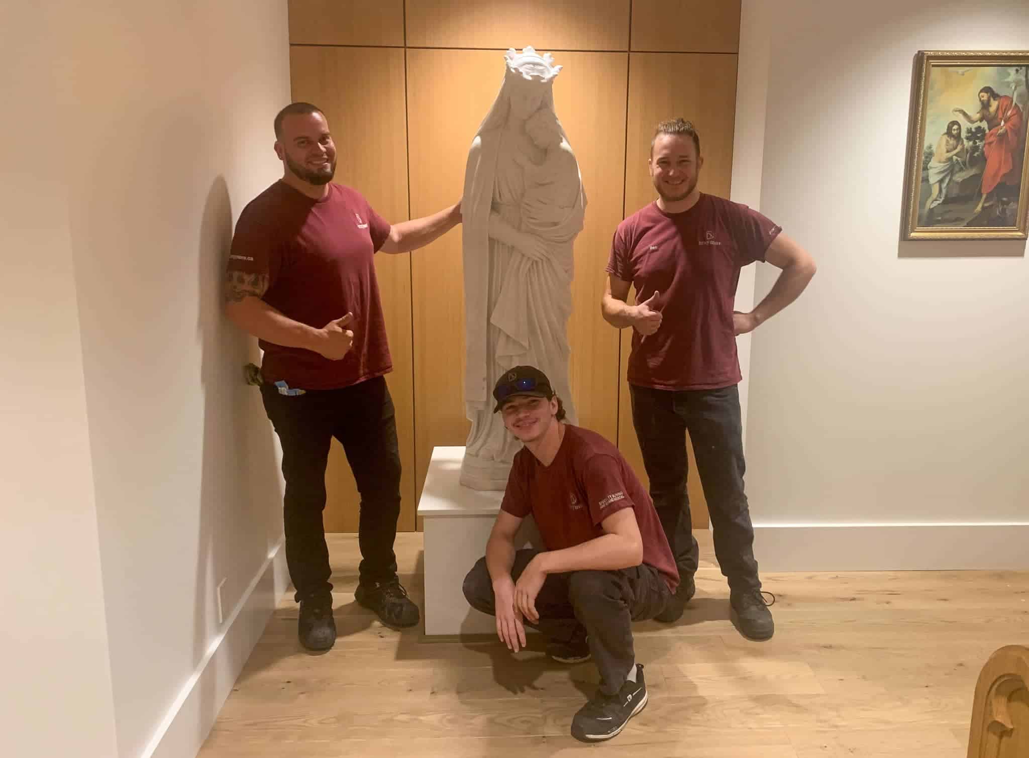 Finished lifting a stone statue onto a pedestal in a church in Hamilton.