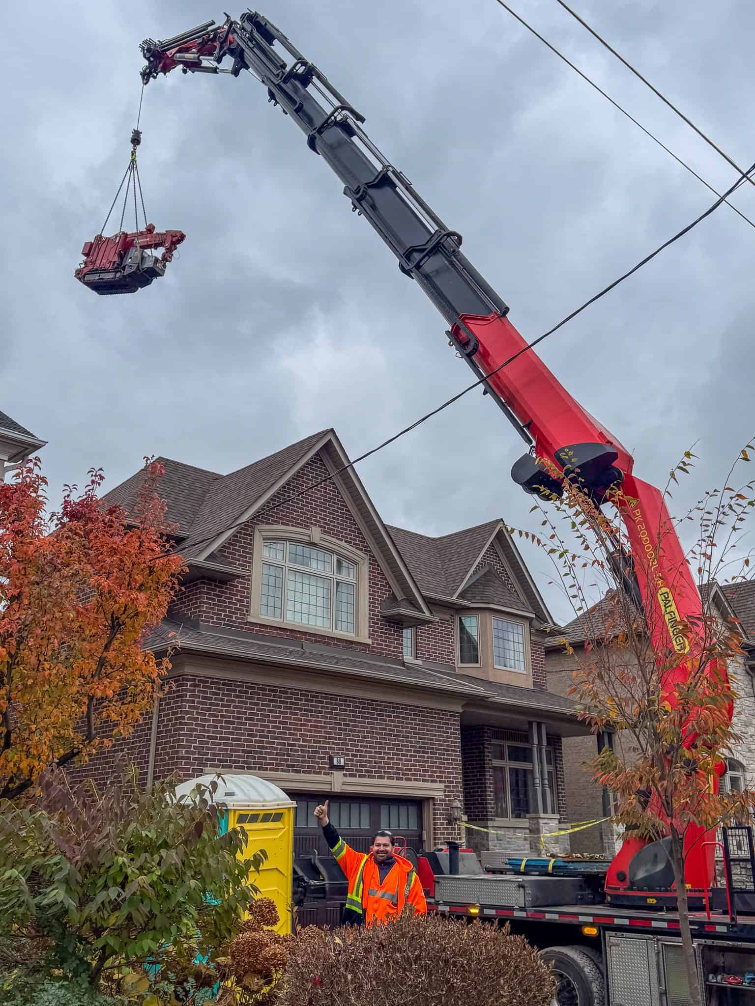 Lifting a Spydercrane 295 into a backyard.