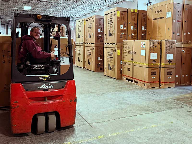 An employee moving boxes in our warehouse with a forklift.