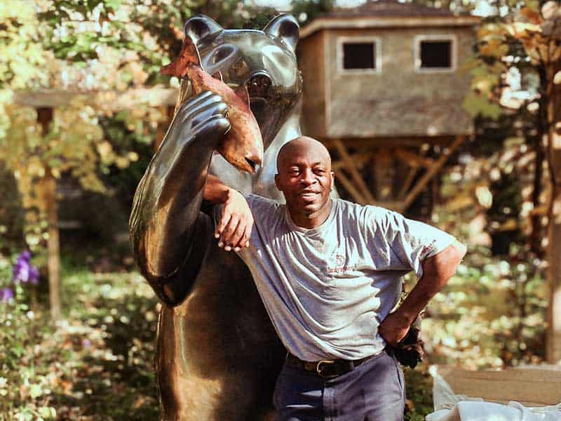 An employee standing in front of a bear statue