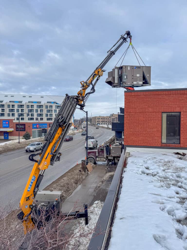 Using the CWE315 mini crane to lift an HVAC onto a building so we do not have to close a lane of traffic on a busy street.