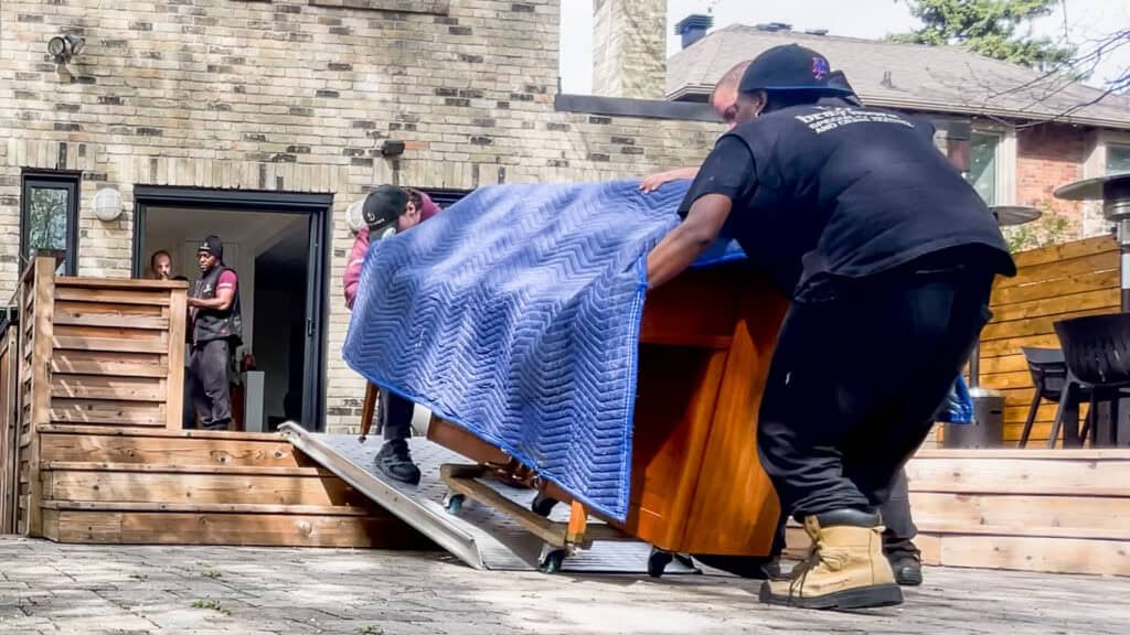 Rolling an upright piano down a ramp off a back porch.