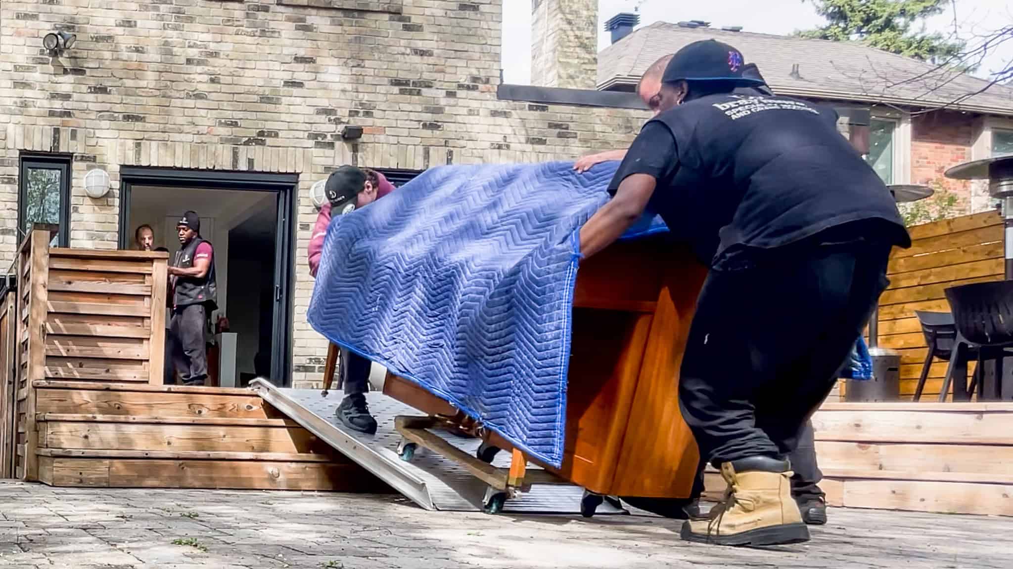 Rolling an upright piano down a ramp off a back porch.