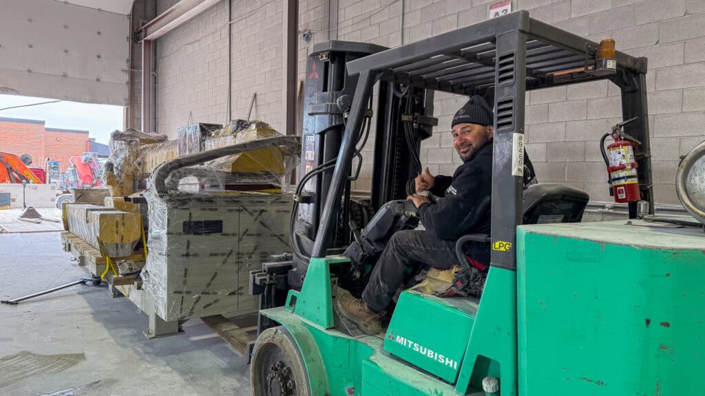 We are using a large forklift to move a large stone cutting table into a workshop.