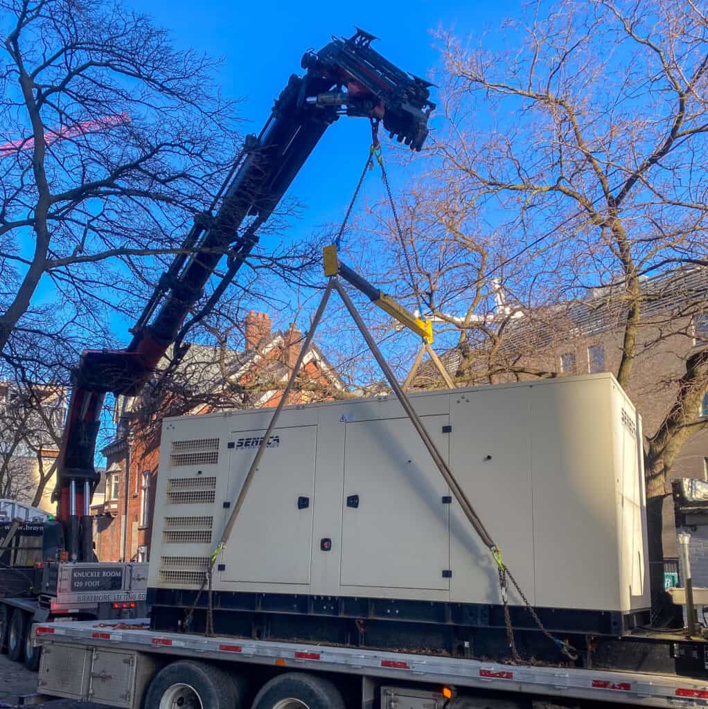 We are using a spreader bar to take the pressure of the straps off the generator being lifted.