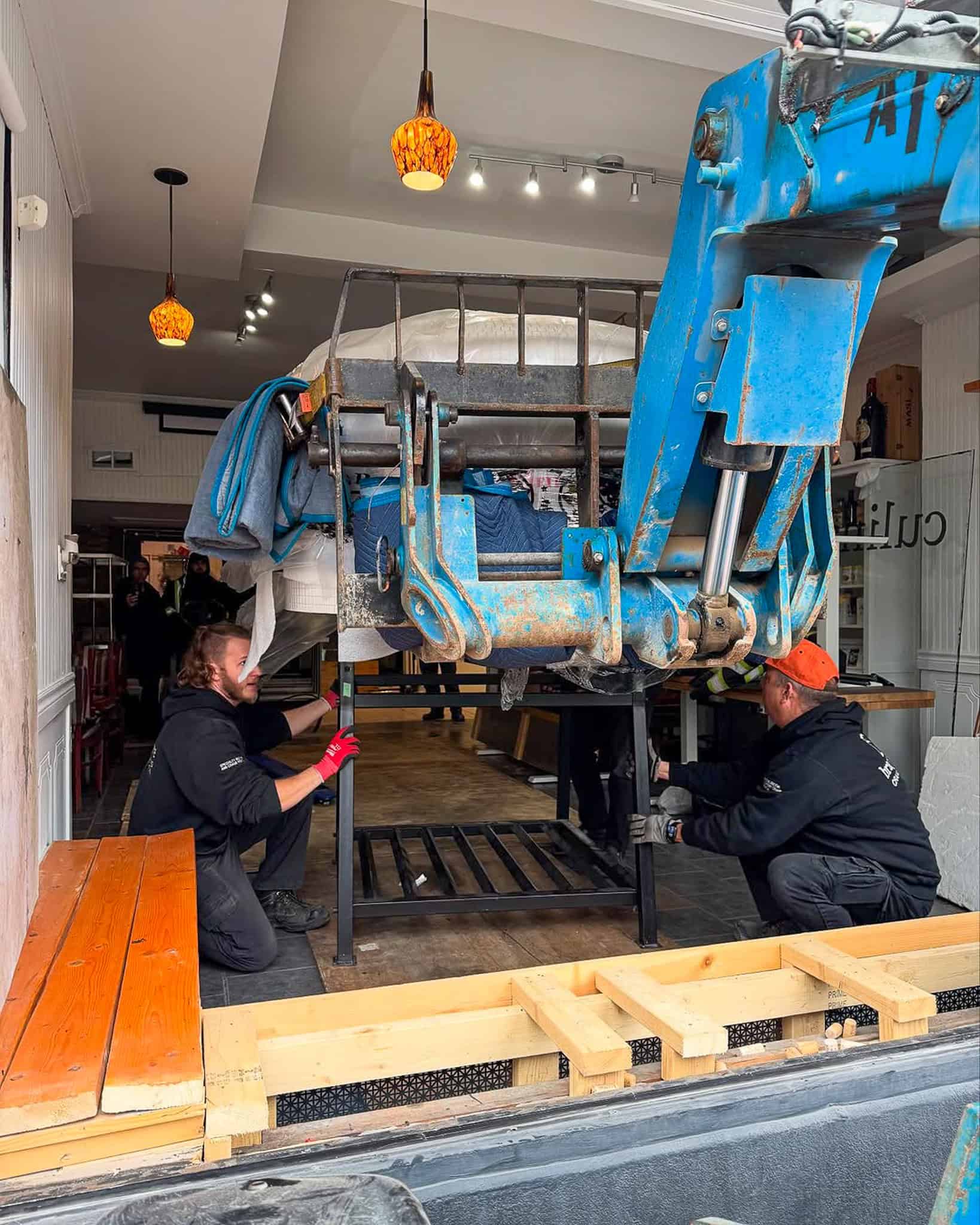 We are using the telehandler to place the 3500-pound pizza oven onto its stand.