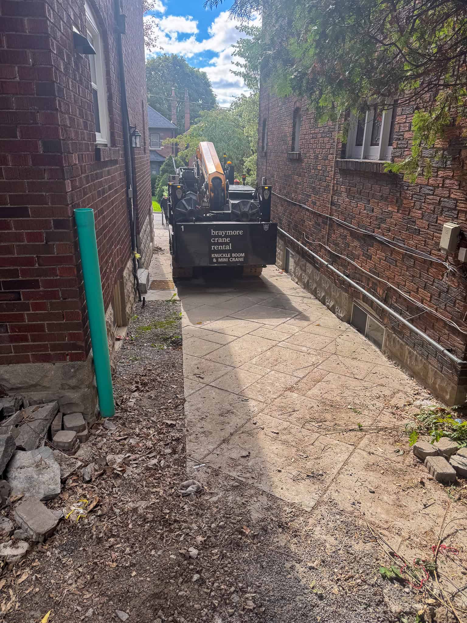 CWE315 Mini Crane driving between two houses to the backyard.