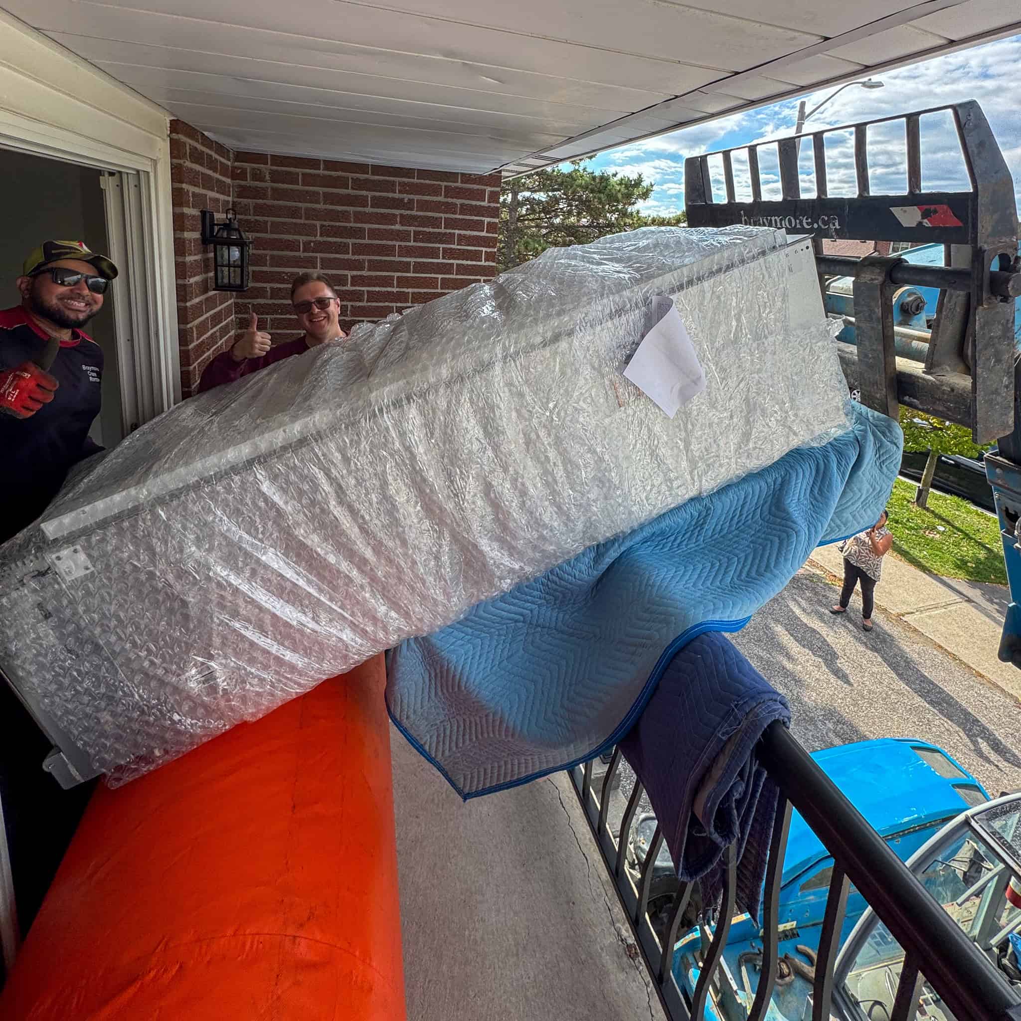 Sliding large fridge onto second floor balcony.